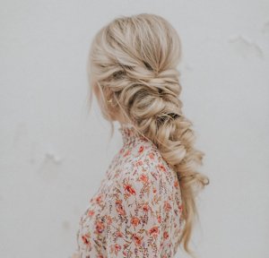 Blonde woman in a floral prom dress with a long fishtail braid